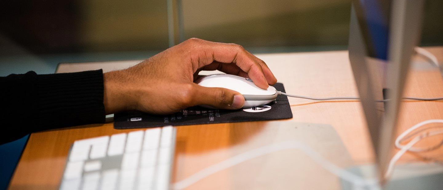 一只手在桌子上使用电脑鼠标