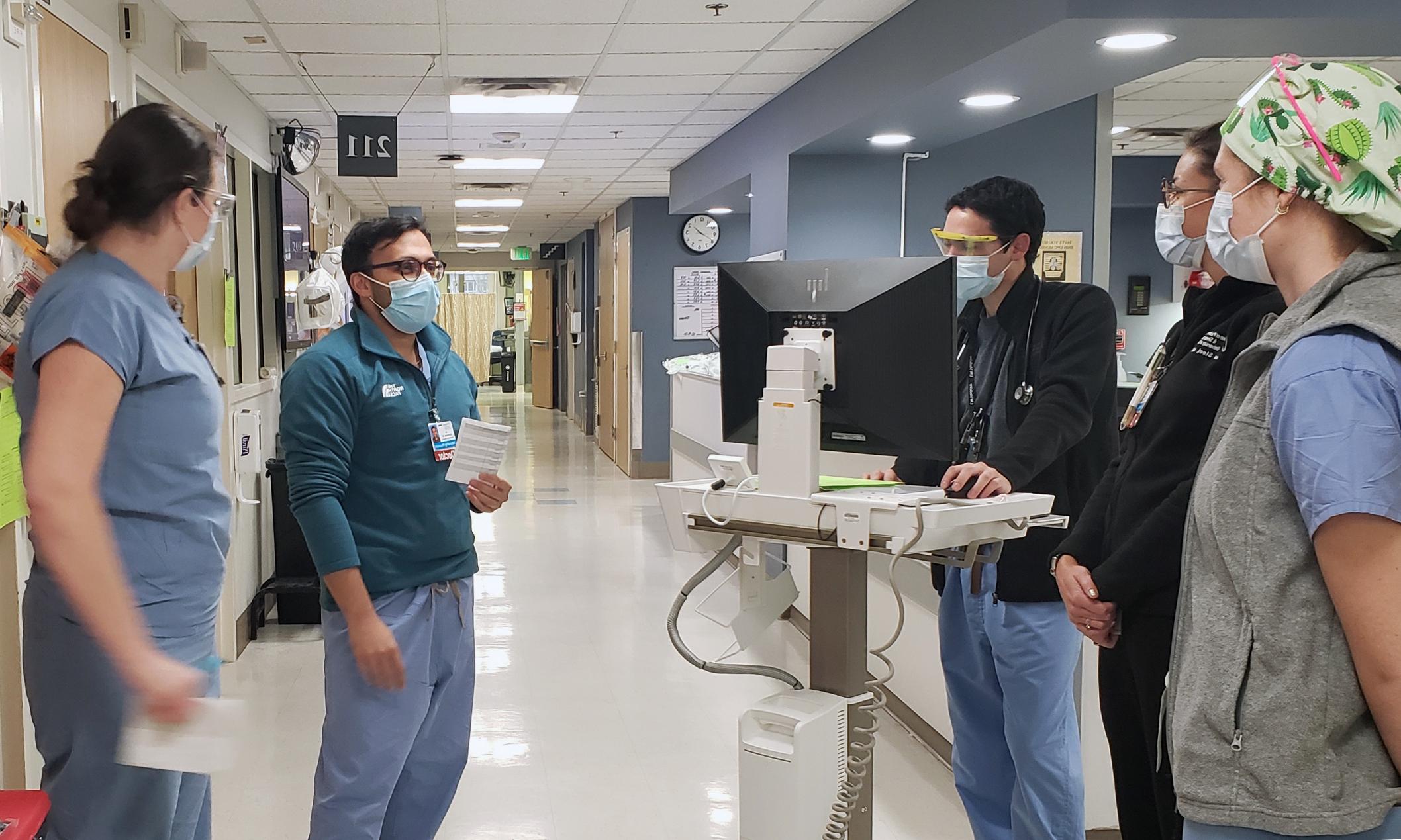 An image of Jay Brahmbhatt, M.D. talking to residents in a hospital setting