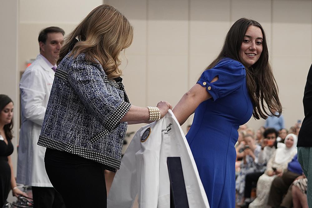 An image of an OUWB student receiving her white coat