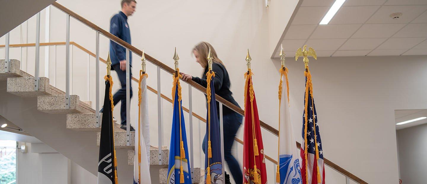 两个人站在一排旗帜后面的楼梯上